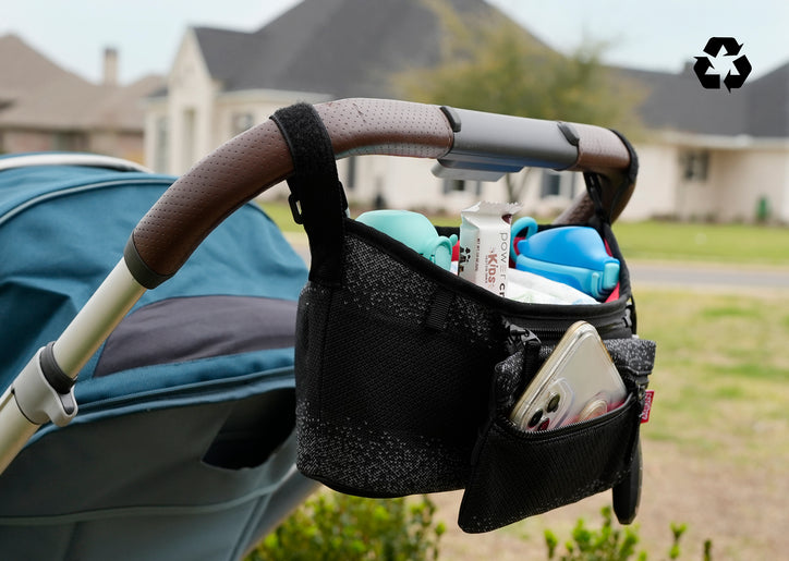 Nuby Eco Stroller Organizer attached to a stroller. The recycling symbol is in the upper-right corner of the image.