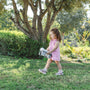 Toddler carrying a Nuby On-the-Go Portable Potty Seat while outside.