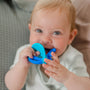 Happy baby chewing on a Nuby teething toy.