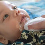 Baby with reflux having spit-up cleaned away
