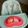 Nuby Green Garden 4-in-1 Multi-Use High Chair with Red Sure Grip Miracle Mat 2-Section Plate on top.
