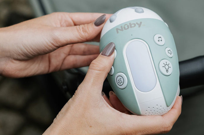 Nuby's Jitterbug stroller rocker in blue-green, in a woman's hands.