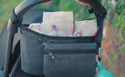 Nuby Eco Stroller Organizer full of supplies, attached to a stroller.