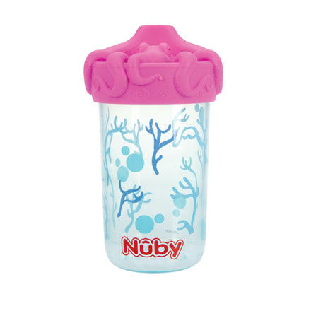 The Nuby 3D Character Soft Spout Sippy Cup | Pink Octopus is clear with a pink lid, blue coral and bubbles, an octopus design, a silicone spout, and the red Nuby logo near the base.