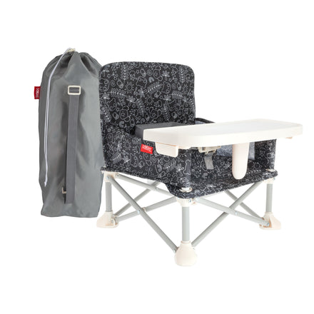 The Nuby Pop Up Booster Seat | Forest features a portable, black-patterned design with a white tray and includes a gray carrying bag. Its foldable frame makes it ideal for young children as a travel booster seat.