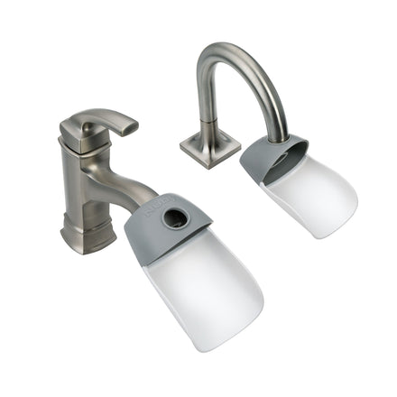 Two silver bathroom faucets fitted with Nuby Sink Faucet Extender (2 Pack), translucent attachments that direct water flow forward—perfect for easier hand washing or use in a kids' bathroom.