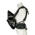 A mannequin torso displays the Deluxe Baby Carrier | Black, featuring padded lumbar support, adjustable straps, and buckles. Shown from the side with the front section open.
