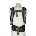 A mannequin displays the Deluxe Baby Carrier | Black, featuring padded shoulder straps, adjustable straps, a chest buckle, and a lumbar-support waist belt, photographed from the back.