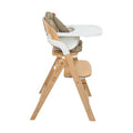 The Grow with Me Foldable High Chair is a wooden adjustable high chair featuring a padded seat, white plastic tray, and an adjustable footrest, shown from a side view against a white background.
