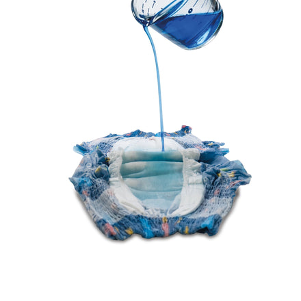 A blue liquid is poured from a beaker onto a Nuby Swim Diaper (5 Pack, Medium), showing its water-resistant absorbency for children against a white background.