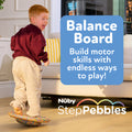 A smiling child balances on colorful foam stones in a living room. Text reads: “StepPebbles and FREE Balance Board | Pastel. Build motor skills with endless ways to play—perfect for indoor or outdoor fun!”.