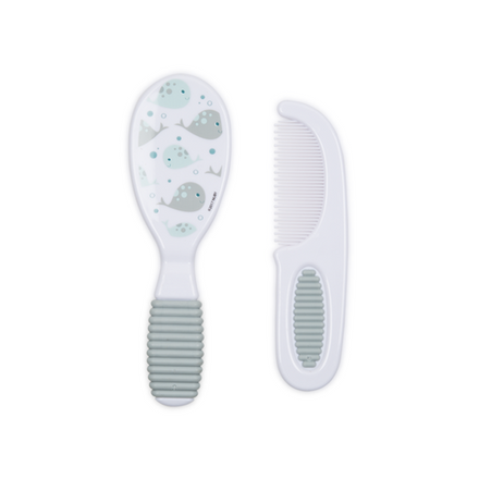 The Nuby Baby's First Comb & Brush set features a soft baby brush with a gray, ribbed handle and whale accents and a matching fine-toothed comb. Both are shown on a white background—ideal for gentle daily care.