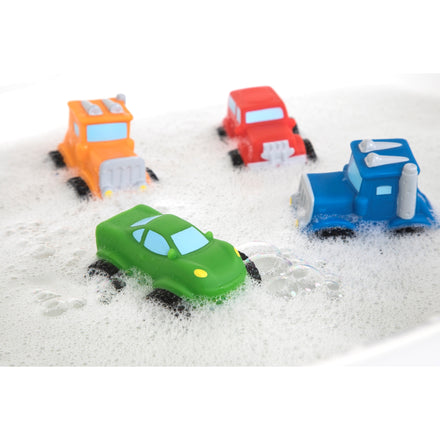 The Nuby Squirt Wheels Bath Squirters 4-pack—featuring a green car, blue truck, red car, and orange truck—float in bubbly bath water, making bath time fun and imaginative for kids.