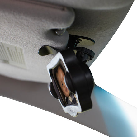 Close-up of the Baby View Mirror attached to a car headrest, providing a multi-angle reflection of a baby's face in a rear-facing car seat.