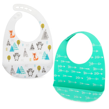 The Nuby Silicone Bib with Crumb Catcher (2 Pack) includes a white bib with woodland animals, trees, and teepees, and a teal bib with white arrows. These waterproof silicone bibs feature adjustable necks and built-in scoop bottoms to catch food.