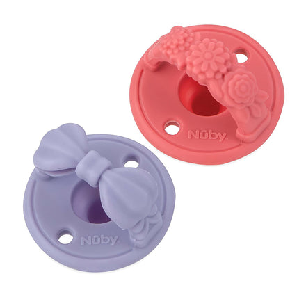 Nuby Sili Soother Pacifier 2 Pack: Includes one lavender pacifier with a bow design and one pink pacifier with a floral pattern, each featuring three small holes and a central opening, perfect for your baby.