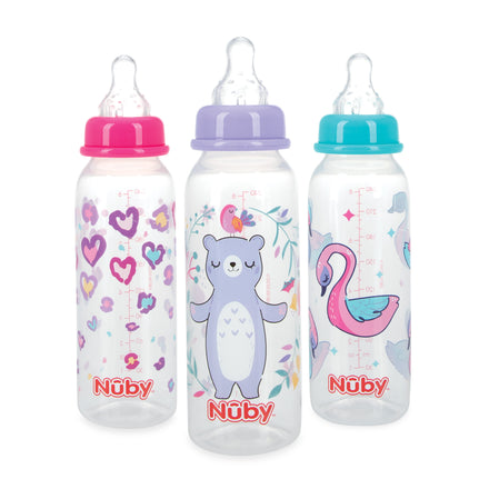 The Nuby Non-Drip Standard Neck Bottle (3 Pack) includes bottles with anti-colic nipples and vari-flo valves, featuring colorful designs: pink hearts and purple flowers, a bear and bird, and a pink flamingo. Each has a clear nipple and cap.