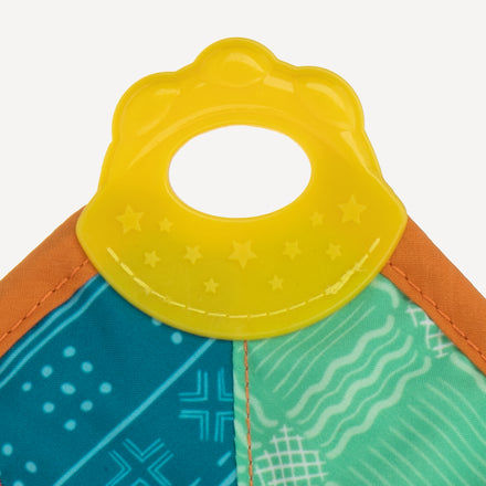 A close-up of the Nuby Plush Pal Teether Blankie shows a yellow plastic teething ring with star patterns, attached to a colorful interactive toy featuring blue, green, and orange crinkle fabric sections with playful designs.